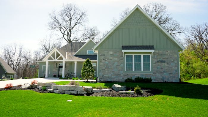 Limestone retaining wall, new sod and planting beds on a new-construction home