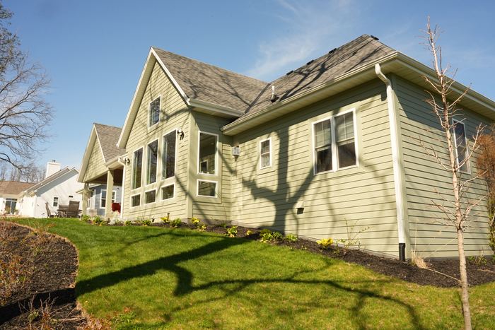 Maintained lawn and clean mulch bed edges along the side of a home