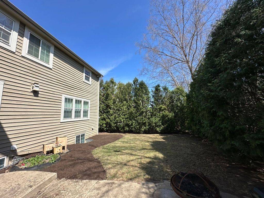 Freshly mulched foundation bed with a clean cut edge along the corner of a home