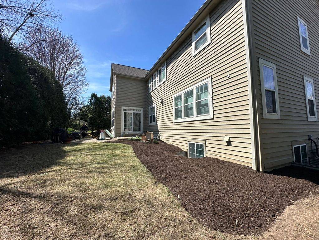 Long freshly mulched bed running the length of a house with a crisp lawn edge