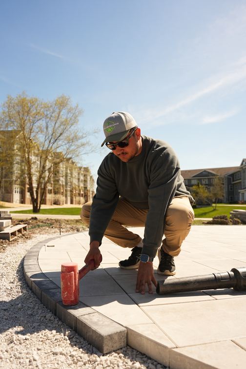 Loyal Landscaping crew member checking a finished paver patio
