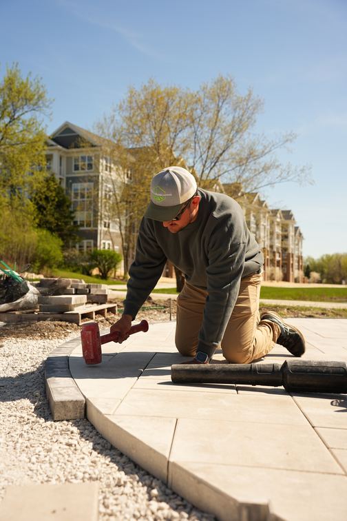 Loyal Landscaping crew member setting the paver edge course on a patio