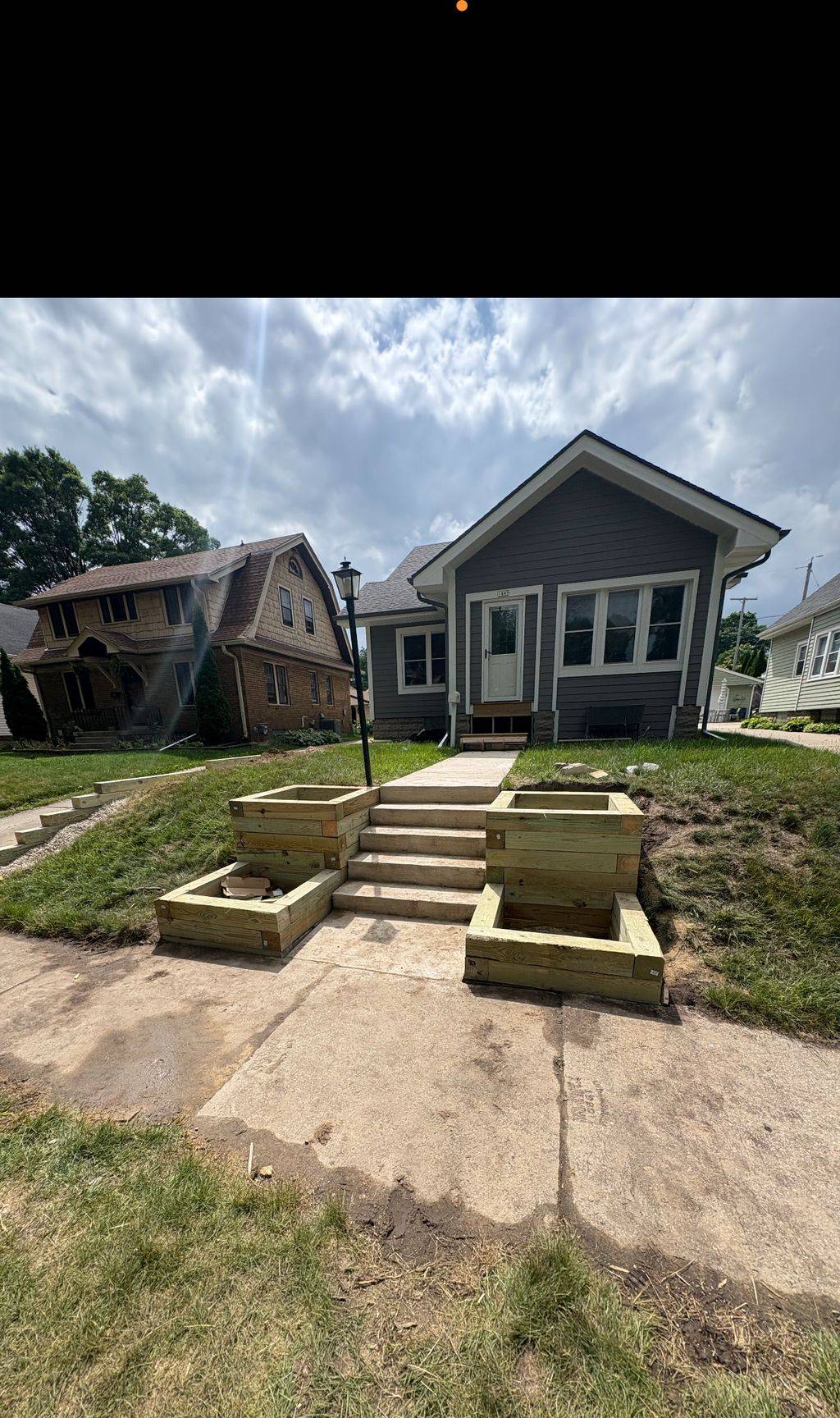 Timber planter boxes flanking new concrete front steps on a Milwaukee bungalow